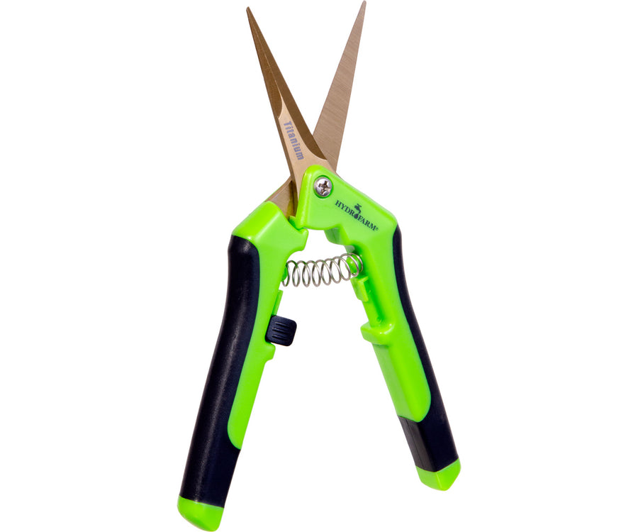 pair of gold colored scissors with green handles